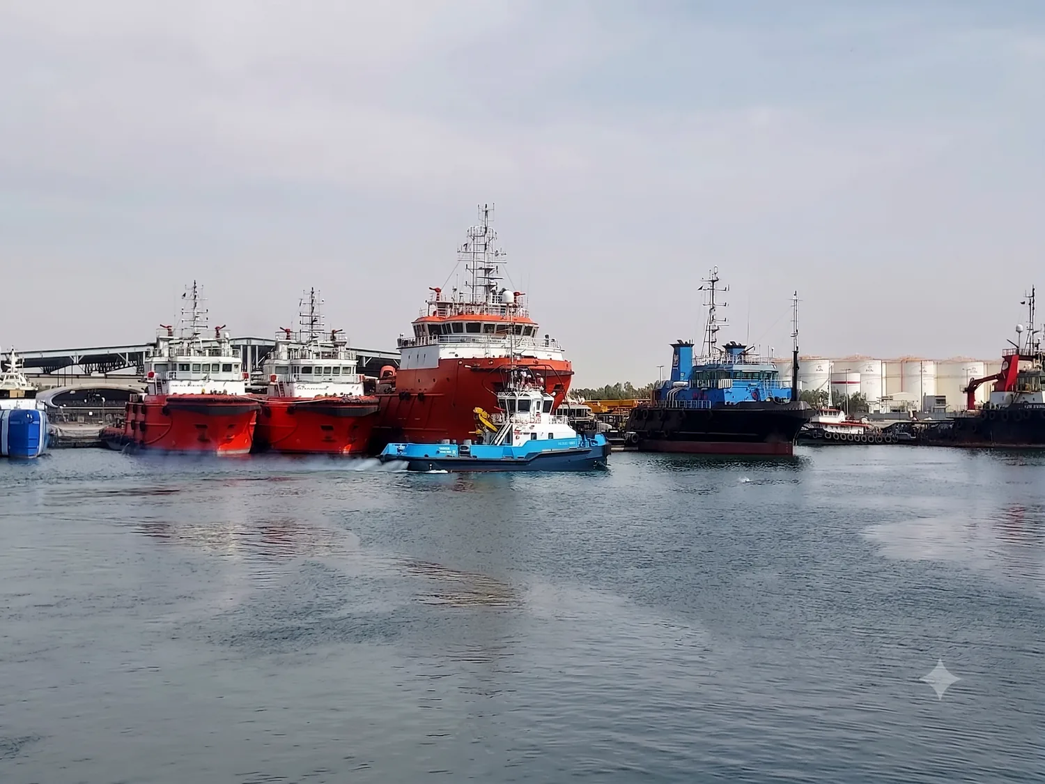 Offshore support vessels and a tug in a UAE harbour